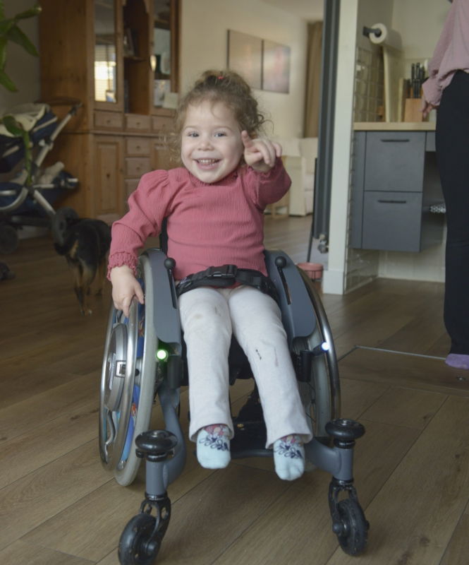Elana kind ambassadeur Spieren voor Spieren Kind Elena in rolstoel. Wijzend naar de camera.